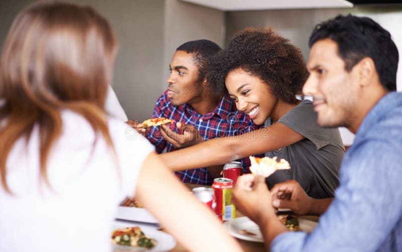 Grupp med vänner och att äta pizza hemma med skratt och social sammankomst för att ha varit med i matsalen. män arkivfoton