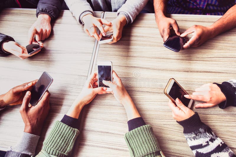 Grupp med vänner som har roligt tillsammans med smarta telefoner - Handlar i sociala nätverk med mobil enhet - Teknik och telefon arkivbild