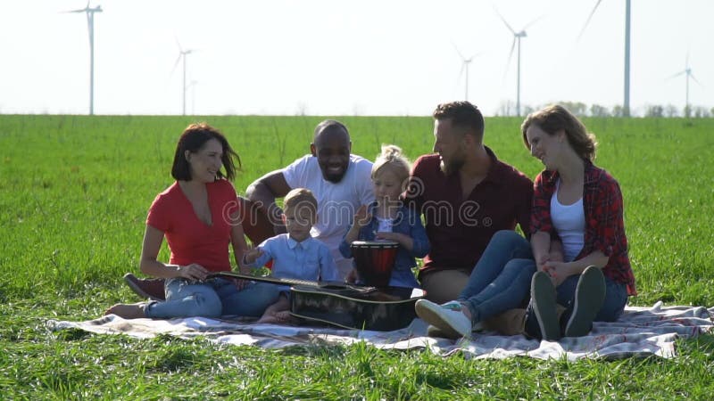 Grupp människor med barn tycker om det underbara vädret på en picknick stock video