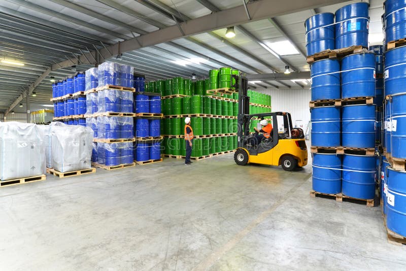 Group of workers in the logistics industry work in a warehouse with chemicals. Group of workers in the logistics industry work in a warehouse with chemicals