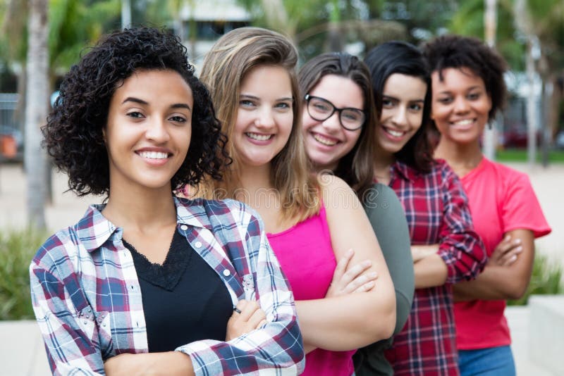 Gruppe des glücklichen internationalen Mädchenschlangestehens lizenzfreies stockbild