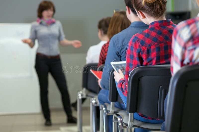 Gruppe des Studenten-hörenden Lektors, der Geräte verwendet lizenzfreie stockfotografie Gruppe des Studenten-hörenden Lektors, der Geräte verwendet lizenzfreie stockfotografie