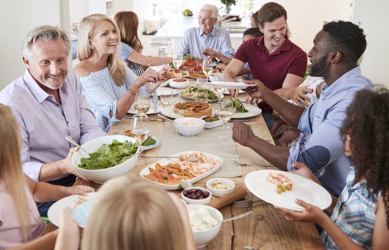 Gruppe Familie von mehreren Generationen und Freunde, die um Tabelle sitzen und Mahlzeit genießen
