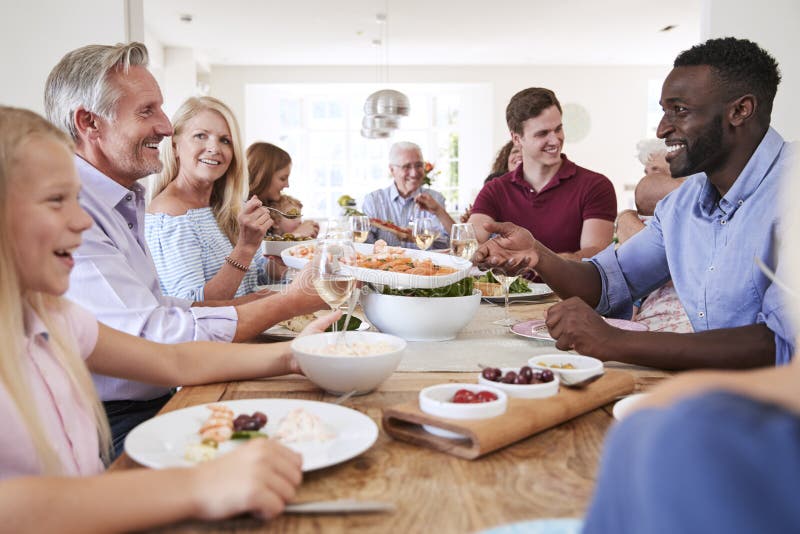 Gruppe Familie von mehreren Generationen und Freunde, die um Tabelle sitzen und Mahlzeit genießen