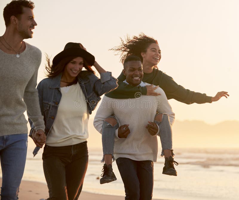 Gruppe Freunde, die den Spaß zusammen läuft entlang Winter-Strand haben stockfoto Gruppe Freunde, die den Spaß zusammen läuft entlang Winter-Strand haben stockfoto
