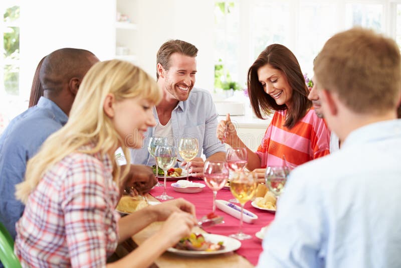 Gruppe Freunde, die um die Tabelle hat Abendessen sitzen stockfotografie Gruppe Freunde, die um die Tabelle hat Abendessen sitzen stockfotografie