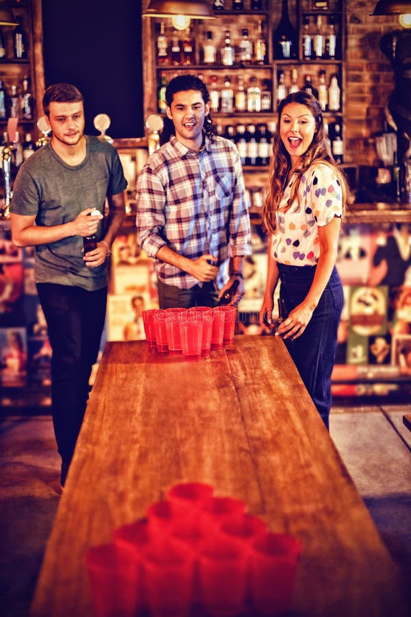 Gruppe glückliche Freunde, die Bier pong Spiel spielen lizenzfreie stockfotos Gruppe glückliche Freunde, die Bier pong Spiel spielen lizenzfreie stockfotos