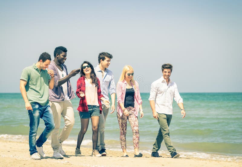 Gruppe glückliche Freunde, die am Strand - gemischtrassig gehen stockbild Gruppe glückliche Freunde, die am Strand - gemischtrassig gehen stockbild
