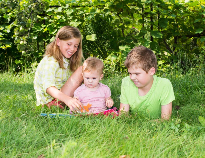 Gruppe glückliche Kinder draußen Zwei Kinder und ein Baby playi stockfotos Gruppe glückliche Kinder draußen Zwei Kinder und ein Baby playi stockfotos