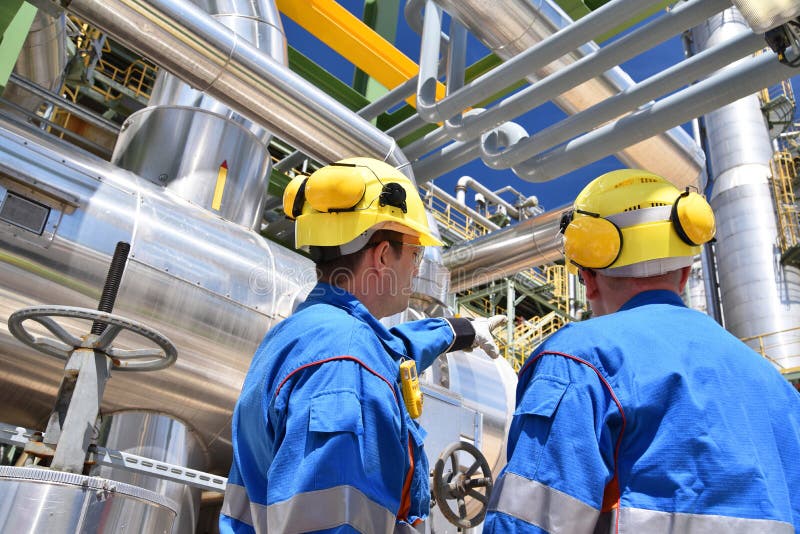 Gruppe Industriearbeiter in einer Raffinerieölverarbeitungsausrüstung und -maschinerie