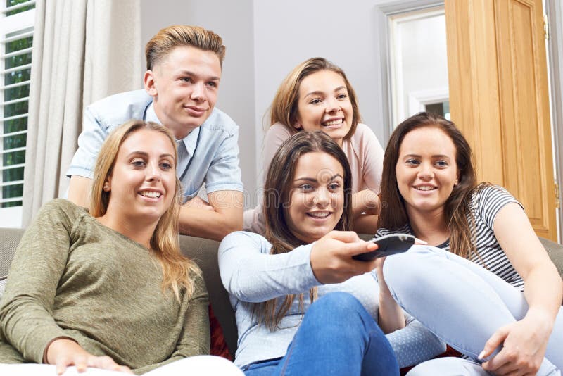 Gruppe Jugendfreunde, die zu Hause fernsehen stockbild Gruppe Jugendfreunde, die zu Hause fernsehen stockbild