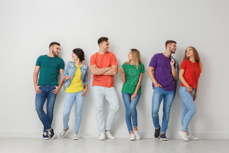Gruppe junge Leute in den Jeans und in den bunten T-Shirts lizenzfreies stockfoto Gruppe junge Leute in den Jeans und in den bunten T-Shirts lizenzfreies stockfoto