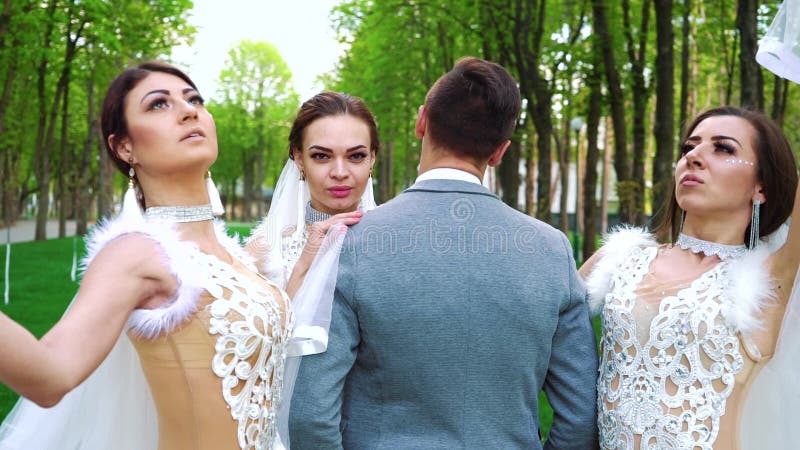 Gruppe junge Leute in der Brautkleidung stehen noch, aufwerfend f?r Kamera