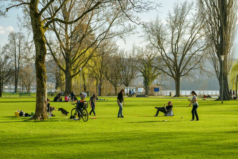 Gruppe junge Leute, die Spiel im kleinen Park an den Ufern von Luzerner See in Luzern spielen stockbild Gruppe junge Leute, die Spiel im kleinen Park an den Ufern von Luzerner See in Luzern spielen stockbild