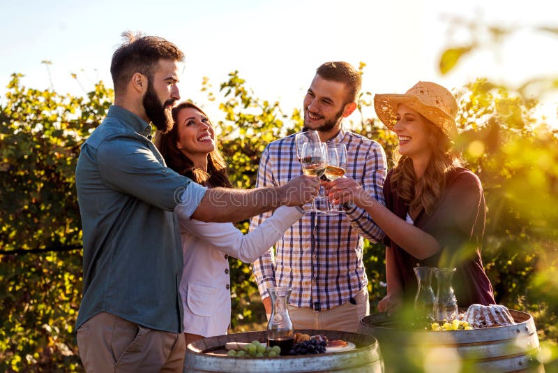 Gruppe junge Leute, die Wein in der Weinkellerei nahe Weinberg schmecken stockfoto Gruppe junge Leute, die Wein in der Weinkellerei nahe Weinberg schmecken stockfoto