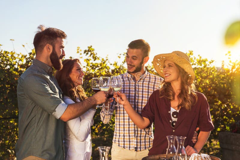 Gruppe junge Leute, die Wein in der Weinkellerei nahe Weinberg schmecken stockbilder Gruppe junge Leute, die Wein in der Weinkellerei nahe Weinberg schmecken stockbilder