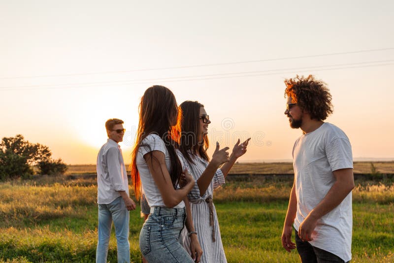 Gruppe junge stilvolle Kerle, die auf der Straße an einem sonnigen Tag sprechen lizenzfreies stockbild Gruppe junge stilvolle Kerle, die auf der Straße an einem sonnigen Tag sprechen lizenzfreies stockbild