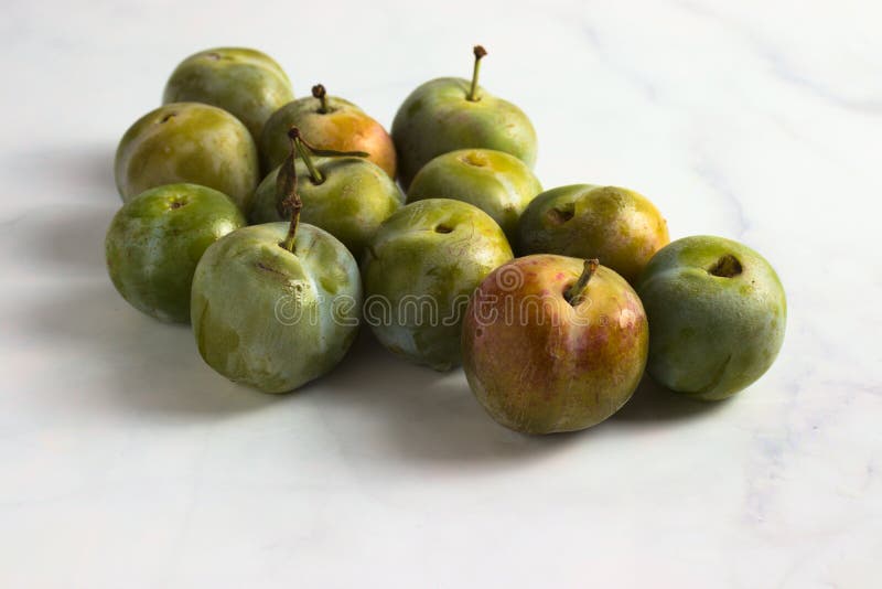 Gruppe kleine Reineclaudenpflaumen auf weißem Marmor stockbilder Gruppe kleine Reineclaudenpflaumen auf weißem Marmor stockbilder