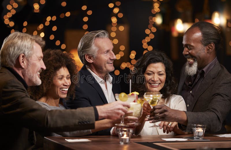 Gruppe Mitte gealterte Freunde, die zusammen in der Stange feiern lizenzfreies stockbild Gruppe Mitte gealterte Freunde, die zusammen in der Stange feiern lizenzfreies stockbild