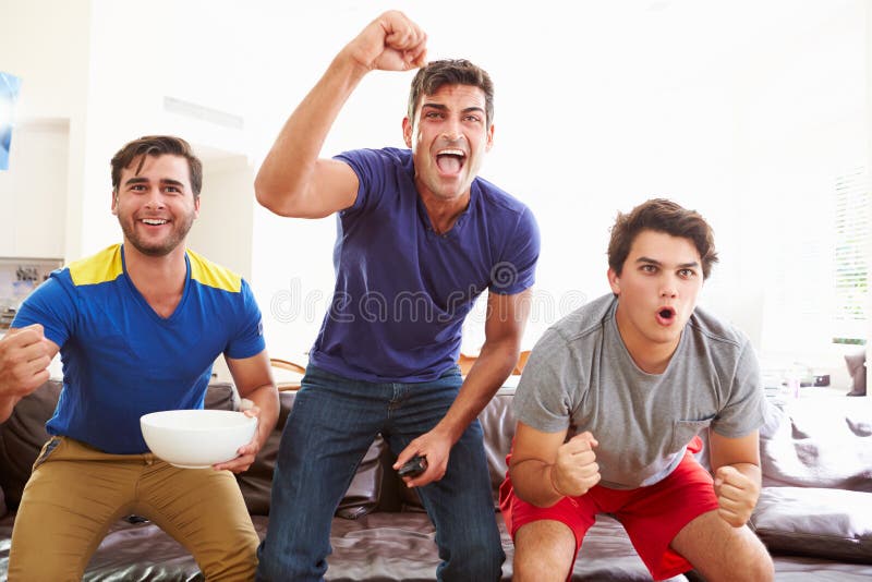 Gruppe Männer, die auf Sofa Watching Sport Together sitzen stockbilder Gruppe Männer, die auf Sofa Watching Sport Together sitzen stockbilder