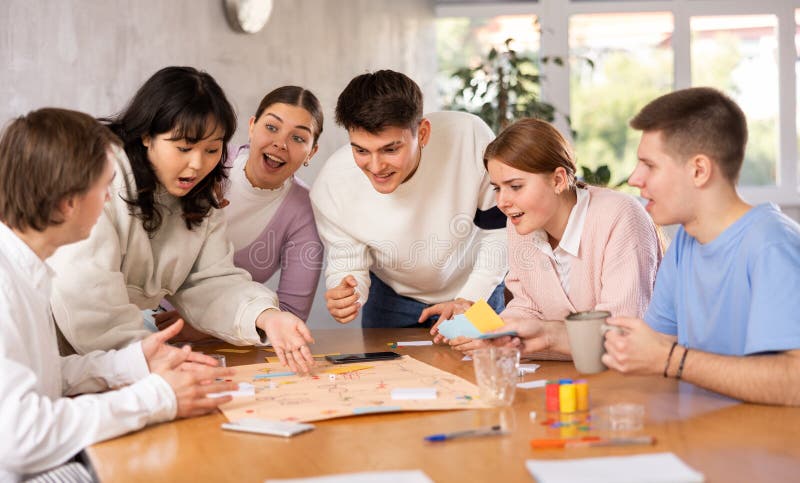 Group of happy young people playing board game. Group of happy young people playing board game