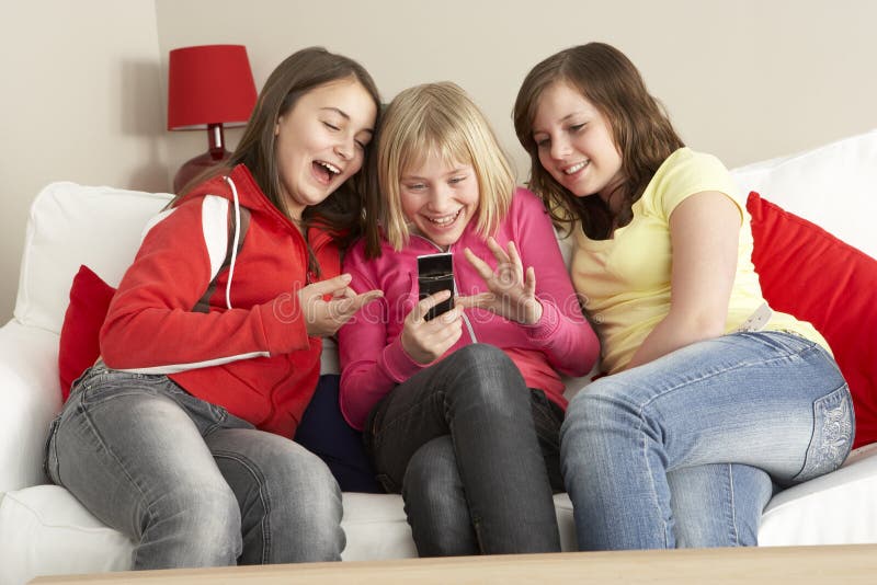Gruppe von drei Mädchen, die Text-Meldung lesen stockbild