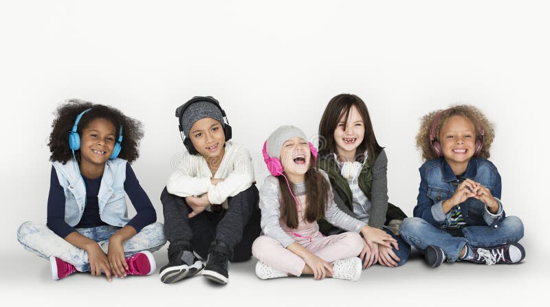 Gruppe von Kinderstudio-lächelnden tragenden Kopfhörern und von Winter C stockfotografie