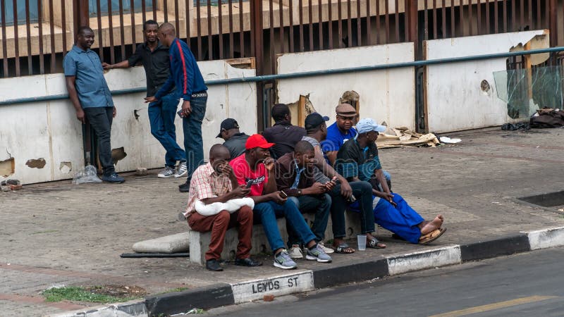 Gruppe von Menschen in Johannesburg, die auf der Straße zusammensitzen, Johannesburg, Südafrika lizenzfreie stockbilder Gruppe von Menschen in Johannesburg, die auf der Straße zusammensitzen, Johannesburg, Südafrika lizenzfreie stockbilder