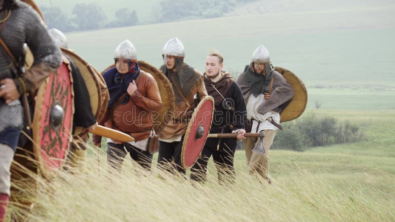 Gruppe von Viking mit Schildern gehend vorwärts auf die Wiese