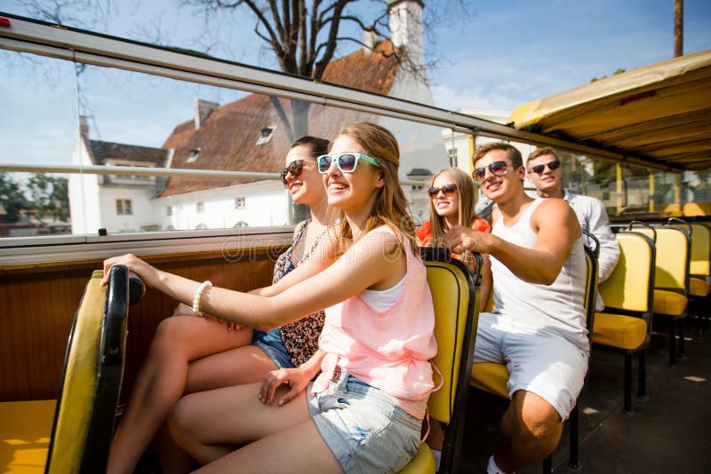 Gruppen av att le vänner som förbi reser, turnerar bussen arkivbild Gruppen av att le vänner som förbi reser, turnerar bussen arkivbild