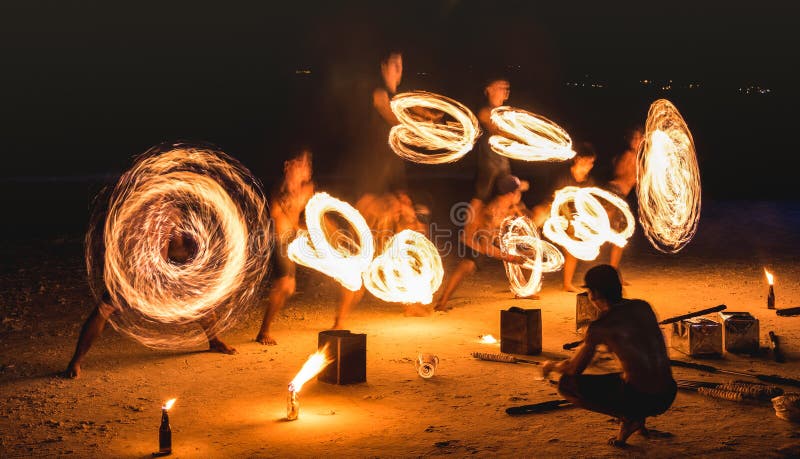 Gruppen av firestarter som utför som förbluffar brandshow med, mousserar på natten - festival för fullmånepartihändelse i Thailan