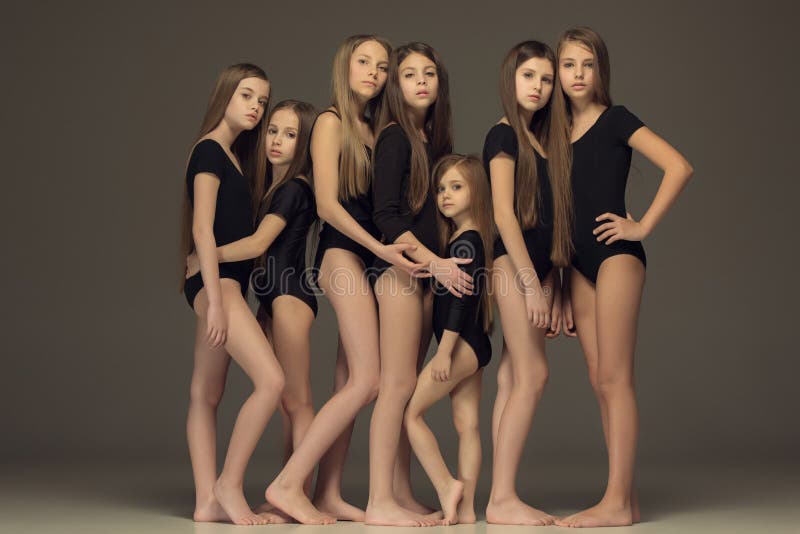 Gruppen av tonåriga flickor som poserar på den vita studion