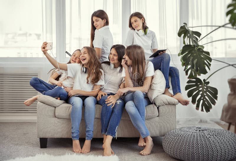 Gruppen av tonårs- flickor gör en selfie Ungar med telefoner, minnestavlor och hörlurar royaltyfria foton Gruppen av tonårs- flickor gör en selfie Ungar med telefoner, minnestavlor och hörlurar royaltyfria foton