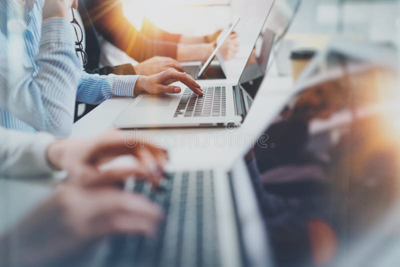 Gruppen av unga coworkers arbetar tillsammans den moderna kontorsstudion horisontalcloseup suddighet bakgrund arkivbild Gruppen av unga coworkers arbetar tillsammans den moderna kontorsstudion horisontalcloseup suddighet bakgrund arkivbild