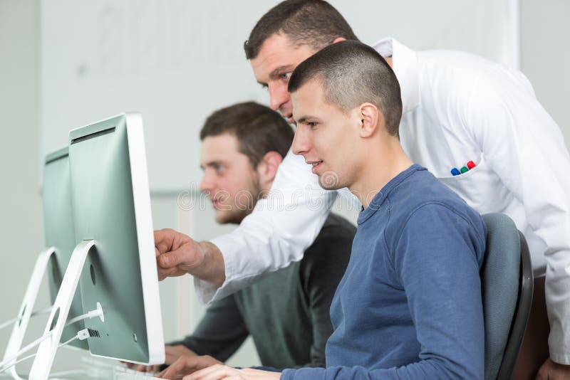 Gruppera studenter med läraren i datorlabbclassrom arkivbilder Gruppera studenter med läraren i datorlabbclassrom arkivbilder