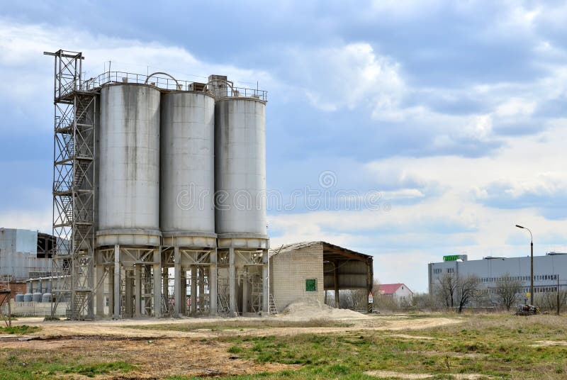 Concrete Batching Plant. Industrial producing cement for construction. Cement manufacturers mine and process raw materials and put them through a chemical reaction process to create cement. Concrete Batching Plant. Industrial producing cement for construction. Cement manufacturers mine and process raw materials and put them through a chemical reaction process to create cement