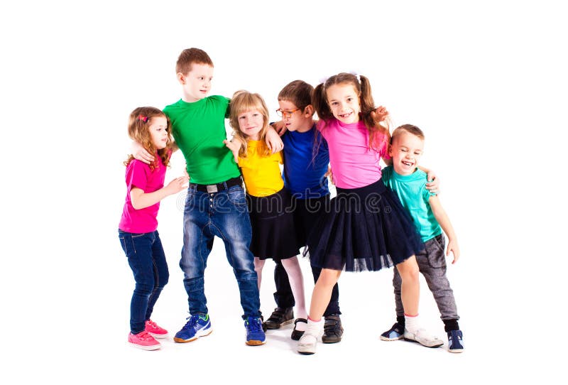 The happy kids are standing together embracing each other in colorful clothes isolated on white background. The happy kids are standing together embracing each other in colorful clothes isolated on white background