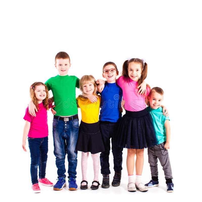 The happy kids are standing together embracing each other in colorful clothes isolated on white background. The happy kids are standing together embracing each other in colorful clothes isolated on white background