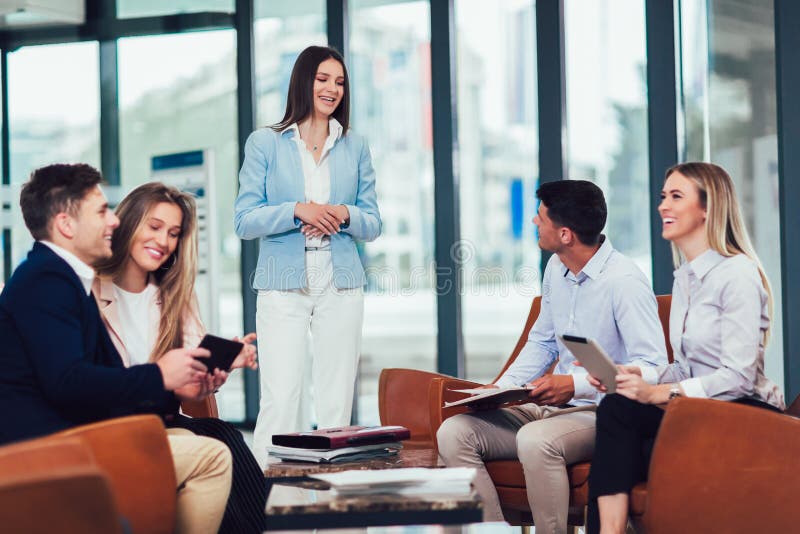 Gruppo che lavora al a nuovi progetto e sorridere Uomo e donne che si siedono insieme nell'ufficio moderno per la discussione di fotografie stock Gruppo che lavora al a nuovi progetto e sorridere Uomo e donne che si siedono insieme nell'ufficio moderno per la discussione di fotografie stock