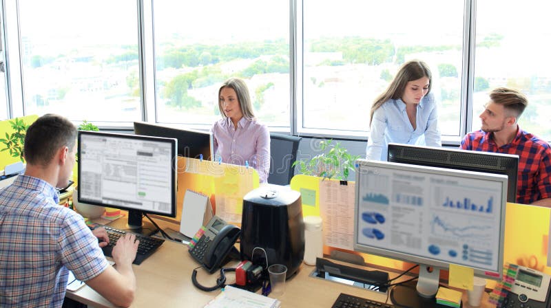Gruppo che lavora nell'ufficio Controlli scrivendo e nuovo discutendo del progetto immagine stock Gruppo che lavora nell'ufficio Controlli scrivendo e nuovo discutendo del progetto immagine stock
