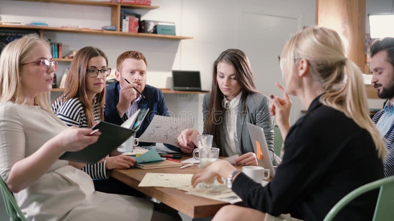 Gruppo creativo di affari alla tavola in un ufficio startup moderno Il capo femminile spiega i dettagli del progetto fotografie stock libere da diritti Gruppo creativo di affari alla tavola in un ufficio startup moderno Il capo femminile spiega i dettagli del progetto fotografie stock libere da diritti