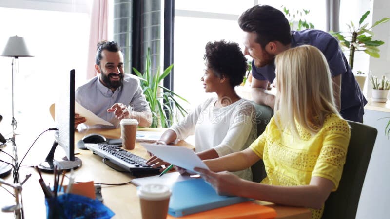 Gruppo creativo felice con i computer in ufficio