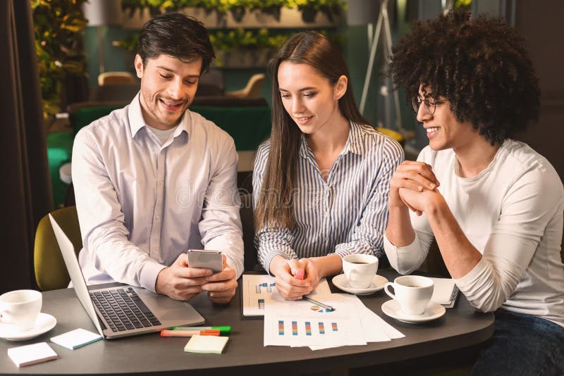 Gruppo di affari sulla riunione che discute progetto con lo smartphone in caff? fotografia stock Gruppo di affari sulla riunione che discute progetto con lo smartphone in caff? fotografia stock