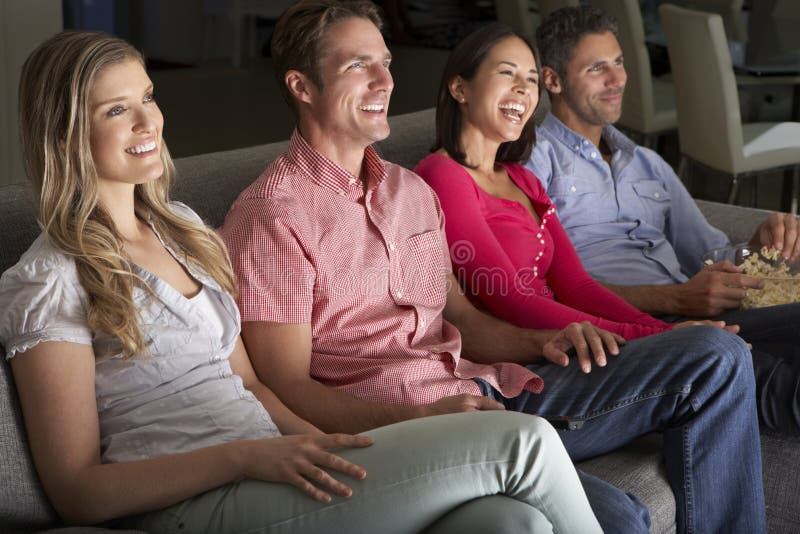Gruppo di amici che si siedono insieme su Sofa Watching TV fotografie stock libere da diritti Gruppo di amici che si siedono insieme su Sofa Watching TV fotografie stock libere da diritti