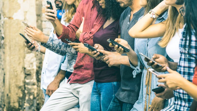Gruppo di amici multiculturali che per mezzo dello Smart Phone mobile fotografia stock
