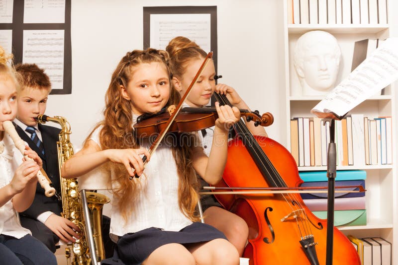 Gruppo di bambini che giocano gli strumenti musicali all'interno fotografia stock libera da diritti Gruppo di bambini che giocano gli strumenti musicali all'interno fotografia stock libera da diritti