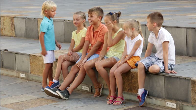 Gruppo di bambini che si siedono sul banco