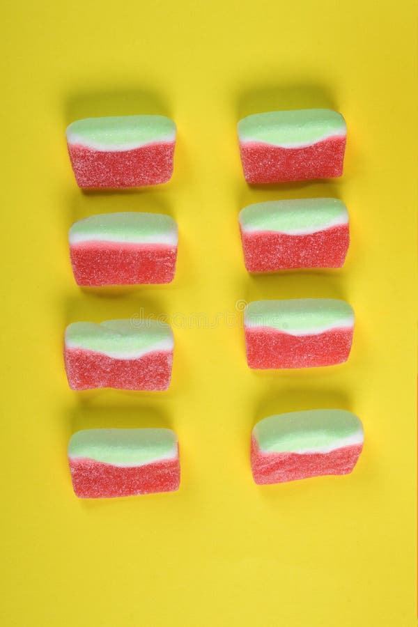 Gruppo di caramelle della gelatina dell'anguria su fondo giallo fotografia stock Gruppo di caramelle della gelatina dell'anguria su fondo giallo fotografia stock