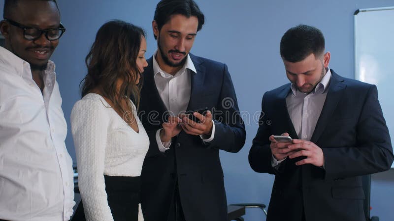 Gruppo di cinque imprenditori multirazziali che utilizzano smartphone