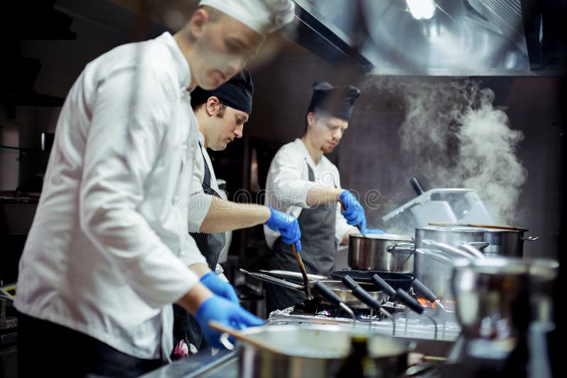 Gruppo di cuochi unici che lavorano nella cucina fotografia stock libera da diritti Gruppo di cuochi unici che lavorano nella cucina fotografia stock libera da diritti